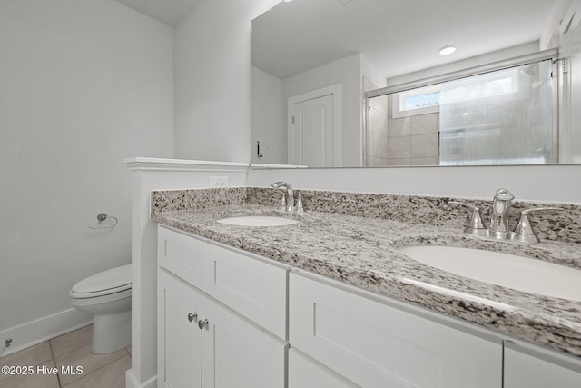 full bath featuring toilet, a stall shower, double vanity, and tile patterned floors