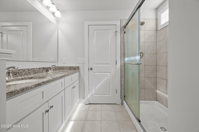 full bathroom with a shower stall, tile patterned flooring, and double vanity