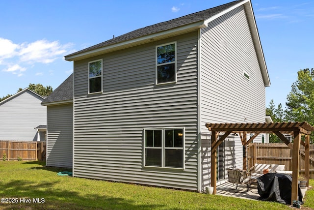 rear view of house featuring a pergola, roof with shingles, and a patio area