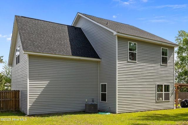 back of property with roof with shingles and central AC unit