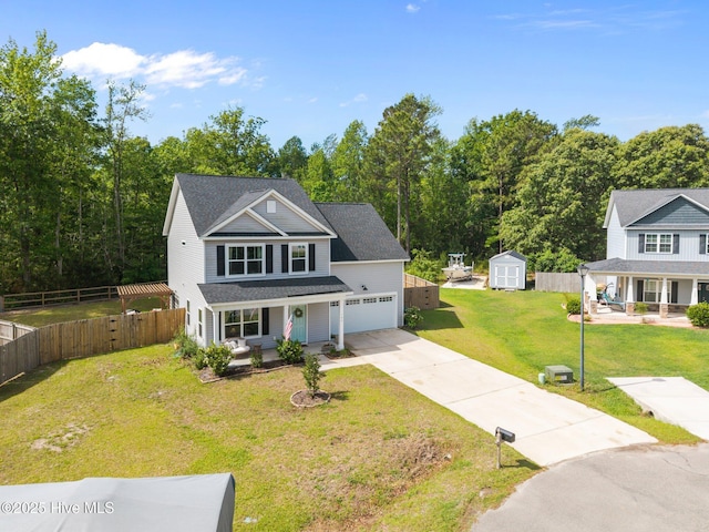 view of front of home with covered porch, driveway, a storage shed, an outbuilding, and an attached garage
