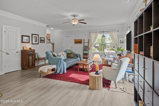 living room featuring light wood-style flooring, ceiling fan, ornamental molding, stairway, and recessed lighting