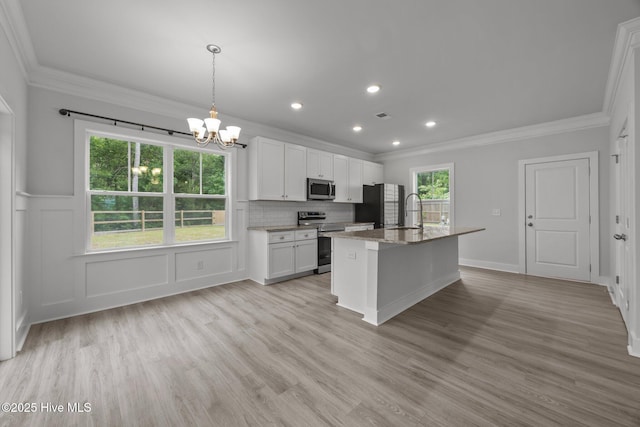 104 Two Sisters Ter, Sneads Ferry, NC 28460 - kitchen with appliances with stainless steel finishes, crown molding, a chandelier, white cabinetry, and a center island with sink