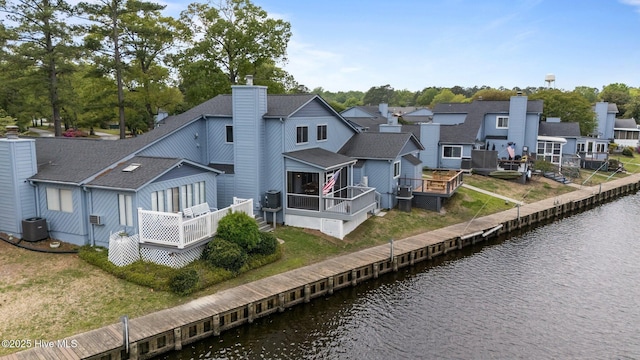 2 Harbour Walk, New Bern, NC 28562 - rear view of property featuring a chimney, roof with shingles, a deck with water view, a sunroom, and a residential view