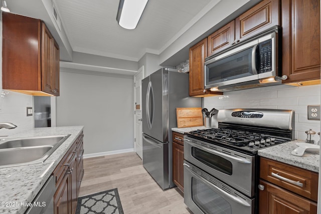 2 Harbour Walk, New Bern, NC 28562 - kitchen with stainless steel appliances, a sink, backsplash, light wood-type flooring, and light stone countertops