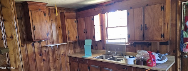 1122 Zion Church Rd, Conway, NC 27820 - kitchen with a sink, light countertops, wood walls, and brown cabinets