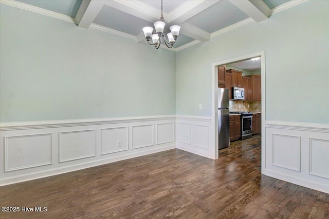 unfurnished dining area with a wainscoted wall, beam ceiling, a chandelier, dark wood-style floors, and coffered ceiling