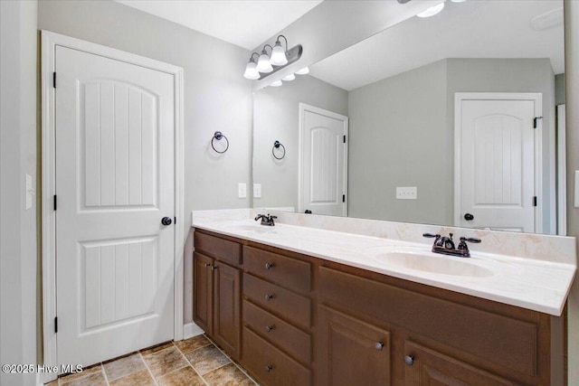 full bathroom with a sink, double vanity, and stone finish floor