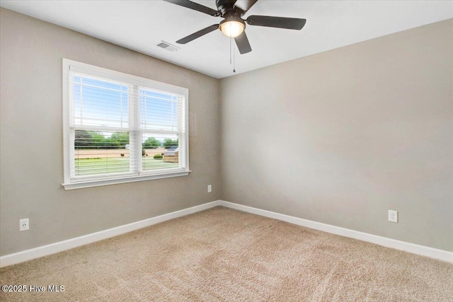 empty room featuring carpet, visible vents, baseboards, and a ceiling fan