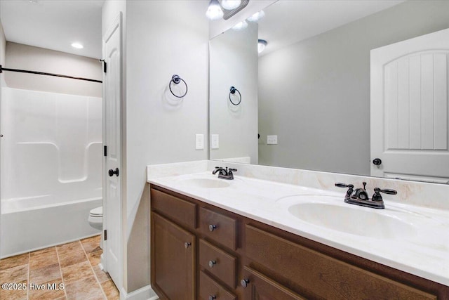 bathroom featuring double vanity, toilet, bathtub / shower combination, and a sink