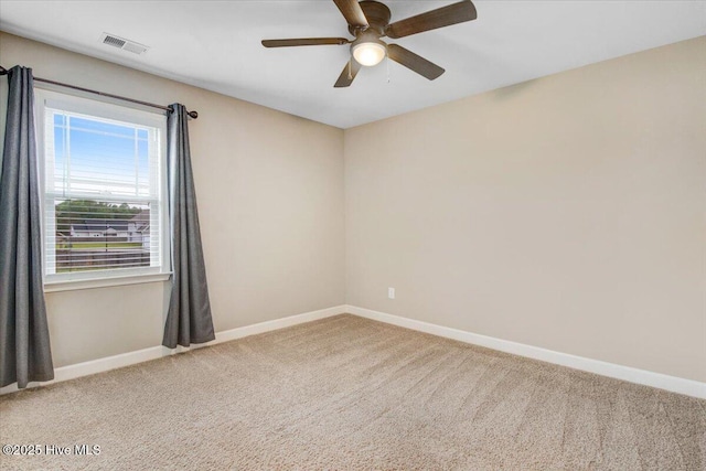 spare room featuring carpet, visible vents, baseboards, and a ceiling fan