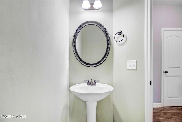 bathroom with a sink, baseboards, and wood finished floors