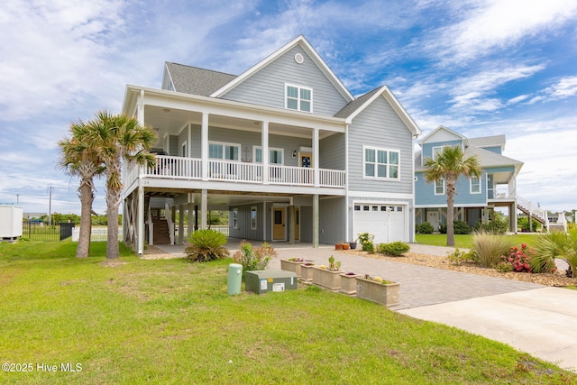 139 Sound Point Dr, Harkers Island, NC 28531 - view of front of property featuring decorative driveway, a front yard, an attached garage, roof with shingles, and covered porch