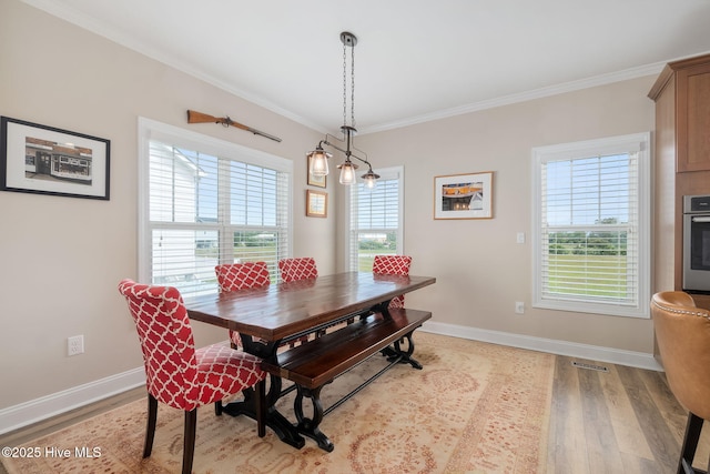 139 Sound Point Dr, Harkers Island, NC 28531 - dining room with light wood-style flooring, crown molding, and baseboards