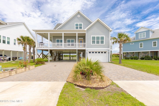 139 Sound Point Dr, Harkers Island, NC 28531 - coastal inspired home with decorative driveway, an attached garage, a front lawn, and a carport