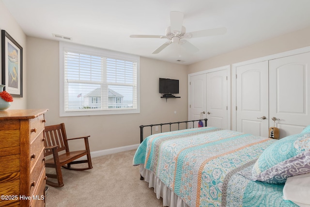 139 Sound Point Dr, Harkers Island, NC 28531 - bedroom with light colored carpet, two closets, baseboards, and ceiling fan