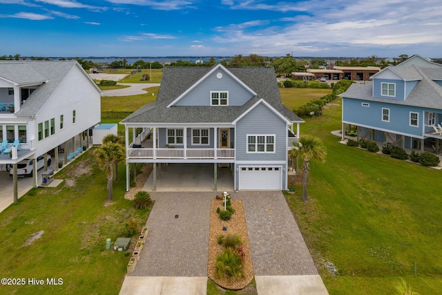 139 Sound Point Dr, Harkers Island, NC 28531 - beach home featuring decorative driveway, an attached garage, roof with shingles, a front yard, and a residential view