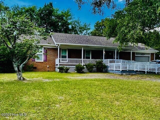 ranch-style home with an attached garage, a shingled roof, crawl space, a porch, and a front lawn