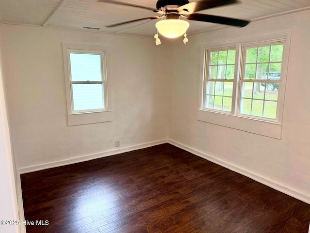 spare room featuring dark wood-type flooring, baseboards, visible vents, and ceiling fan