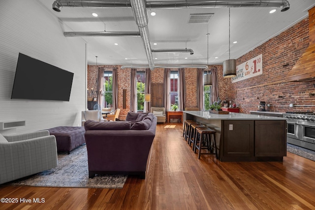 221 Craven St, New Bern, NC 28560 - living area featuring brick wall, wood finished floors, and recessed lighting