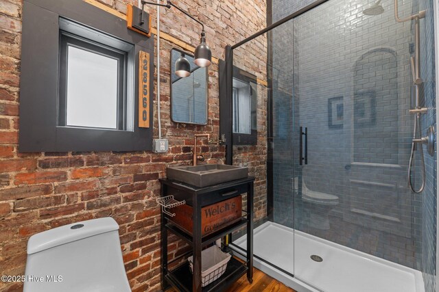 221 Craven St, New Bern, NC 28560 - bathroom featuring toilet, a stall shower, vanity, and brick wall