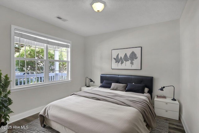 bedroom with baseboards and wood finished floors