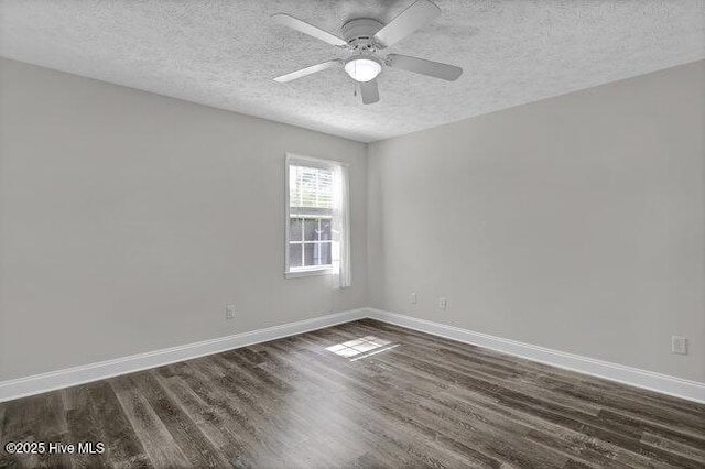 empty room with a textured ceiling, dark wood-style floors, baseboards, and a ceiling fan