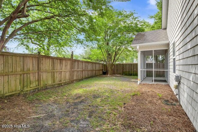 fenced backyard with a sunroom