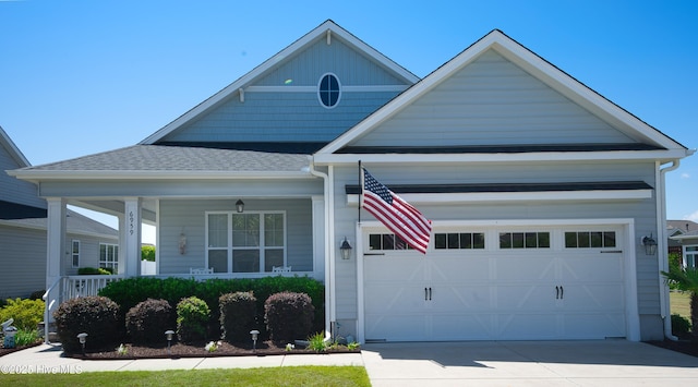 6959 Gracieuse Ln SW, Ocean Isle Beach, NC 28469 - view of front of home with an attached garage, concrete driveway, a shingled roof, and covered porch