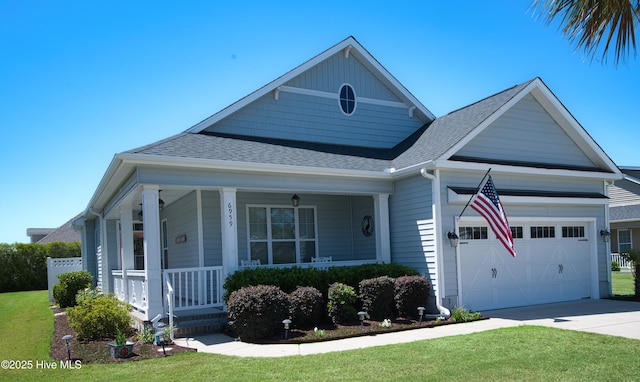 6959 Gracieuse Ln SW, Ocean Isle Beach, NC 28469 - view of front of home featuring a shingled roof, covered porch, an attached garage, and concrete driveway