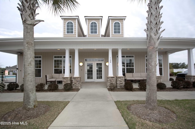 6959 Gracieuse Ln SW, Ocean Isle Beach, NC 28469 - view of front of house with french doors, an outdoor living space, covered porch, and board and batten siding