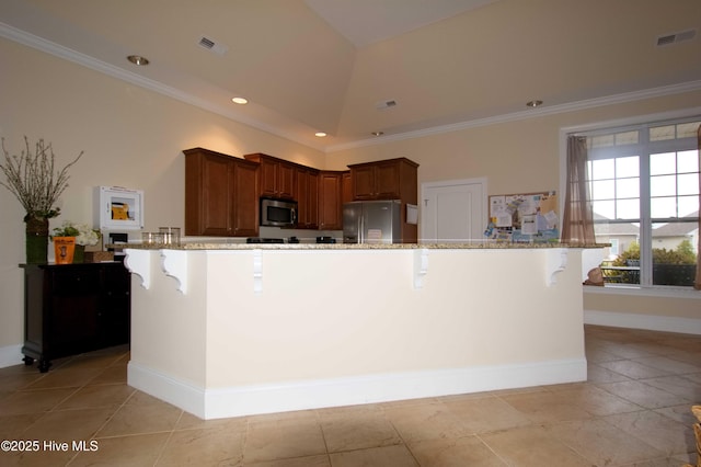 6959 Gracieuse Ln SW, Ocean Isle Beach, NC 28469 - kitchen featuring stainless steel appliances, a kitchen breakfast bar, light stone countertops, ornamental molding, and baseboards