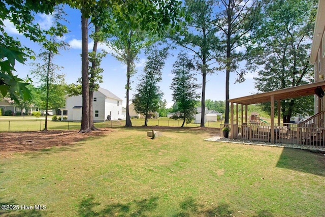 view of yard featuring playground community and fence