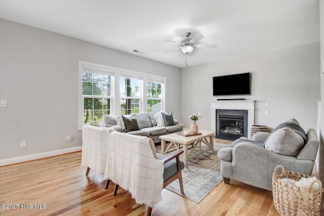 living area featuring ceiling fan, light wood-style flooring, baseboards, and visible vents