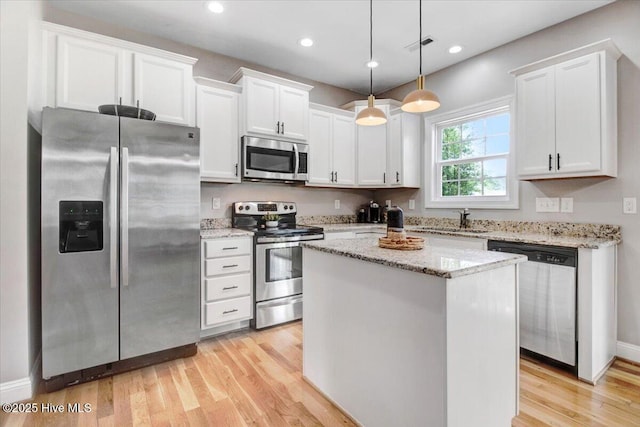 kitchen featuring light wood-type flooring, white cabinets, appliances with stainless steel finishes, and a sink