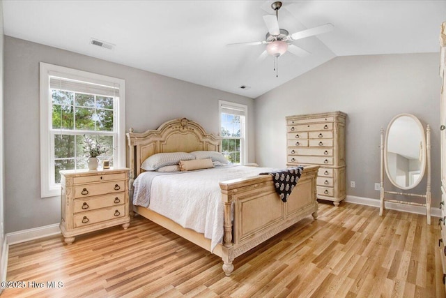 bedroom with light wood-style floors, visible vents, baseboards, and lofted ceiling
