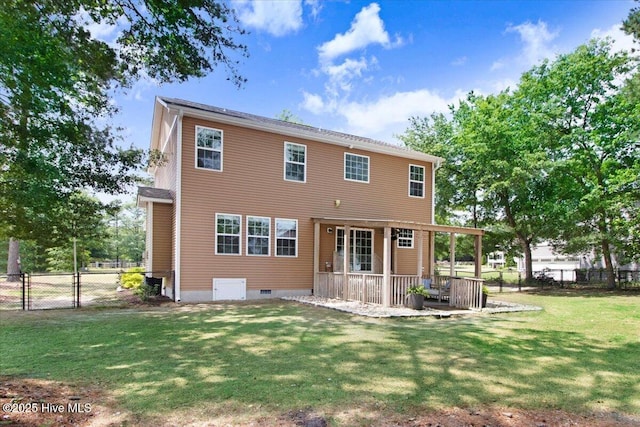 rear view of property featuring a lawn, a patio area, and fence