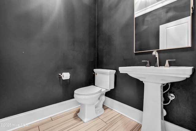 half bathroom with toilet and baseboards