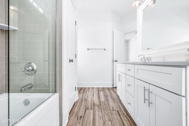 bathroom featuring shower / bathtub combination, vanity, wood finished floors, and baseboards