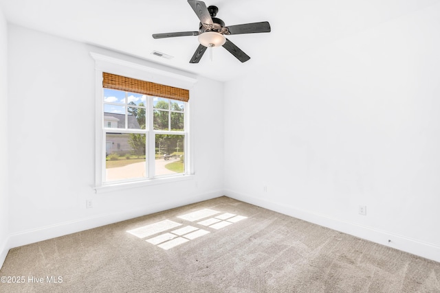 spare room featuring carpet, baseboards, and a ceiling fan