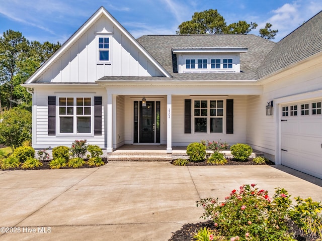 entrance to property featuring a porch, board and batten siding, roof with shingles, and a garage