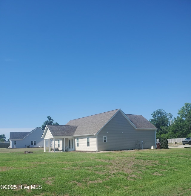 rear view of house featuring a lawn and a sunroom
