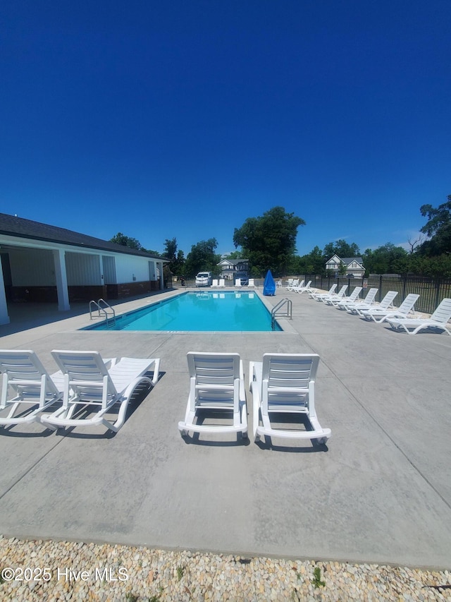 community pool with fence and a patio