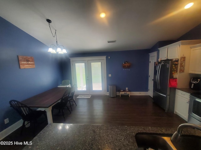 kitchen featuring freestanding refrigerator, white cabinets, baseboards, stove, and lofted ceiling