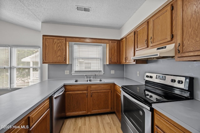 123 W Victoria Ct Unit F, Greenville, NC 27834 - kitchen with stainless steel appliances, under cabinet range hood, a sink, a textured ceiling, and light countertops