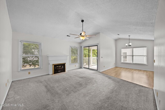 123 W Victoria Ct Unit F, Greenville, NC 27834 - unfurnished living room featuring carpet flooring, lofted ceiling, a ceiling fan, a fireplace with flush hearth, and a textured ceiling
