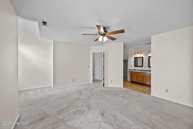 123 W Victoria Ct Unit F, Greenville, NC 27834 - unfurnished living room with light carpet, ceiling fan, baseboards, and a textured ceiling
