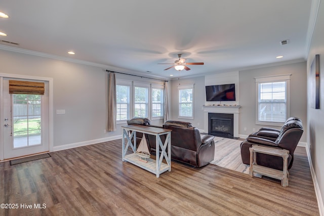 519 W Craftsman Way, Hampstead, NC 28443 - living area with ornamental molding, healthy amount of natural light, recessed lighting, a glass covered fireplace, and a ceiling fan