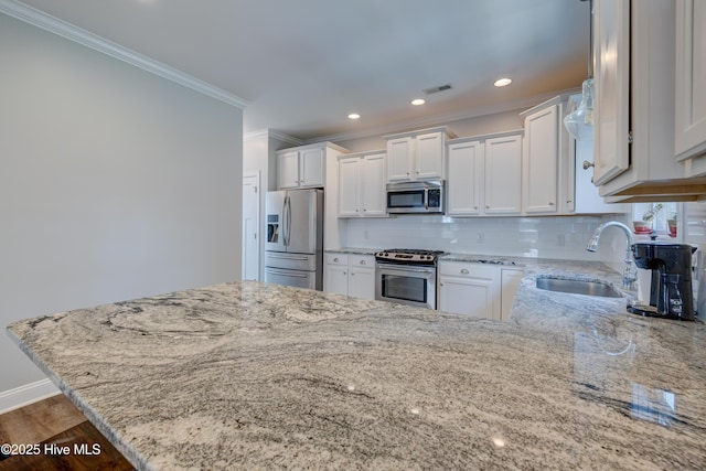 519 W Craftsman Way, Hampstead, NC 28443 - kitchen featuring stainless steel appliances, a sink, light stone counters, a peninsula, and ornamental molding