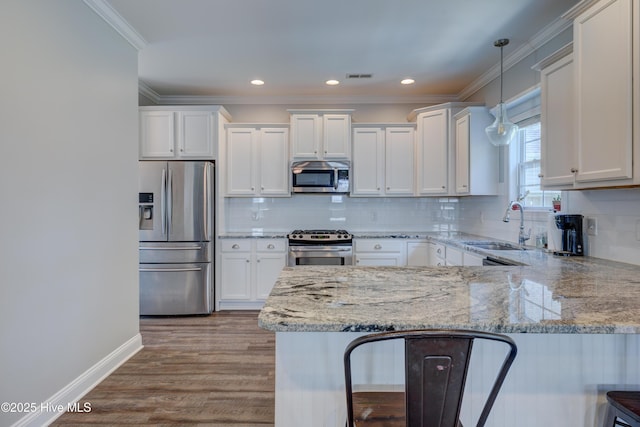 519 W Craftsman Way, Hampstead, NC 28443 - kitchen with stainless steel appliances, a sink, white cabinetry, a peninsula, and crown molding